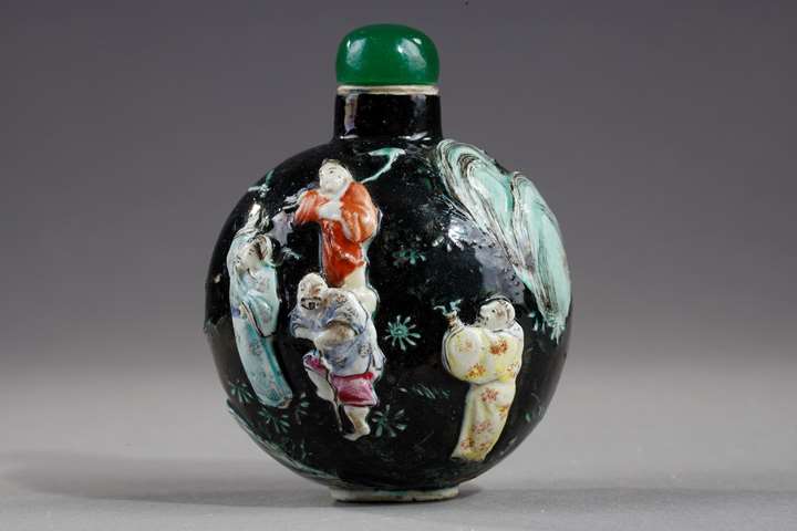 Snuff bottle porcelain molded with eight immortals on a dark green background
